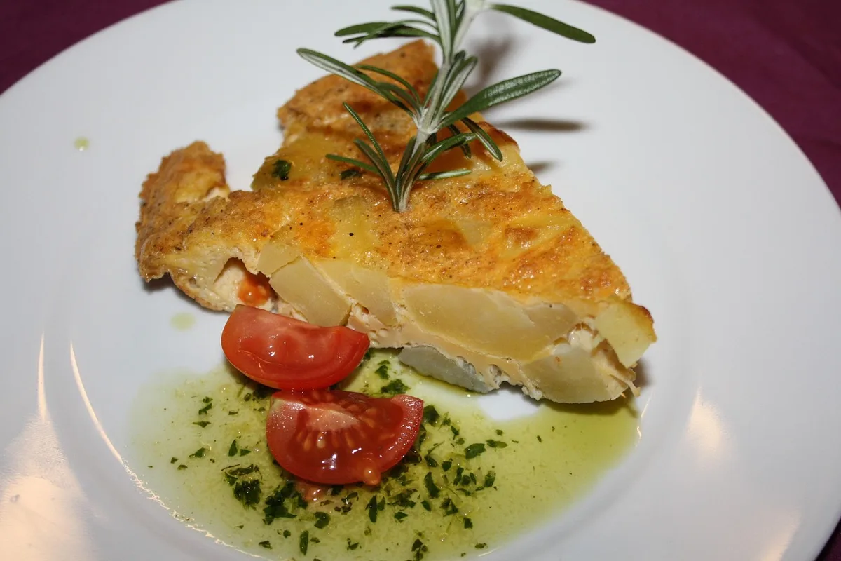 A classic Spanish tortilla de patatas served with cherry tomatoes