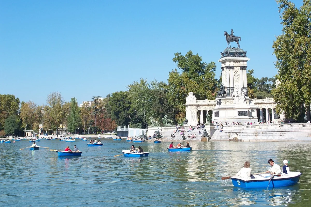 Rowboats on the Estanque Grande lake in Retiro Park, with the Alfonso XII monument behind